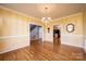 Formal dining room with hardwood floors, chandelier, and yellow striped walls at 1107 Fox Chase Dr, Newton, NC 28658