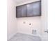 Laundry room with gray cabinets and gray tile floor at 1364 Cedardale Ln, Denver, NC 28037