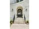 Elegant front entry with arched doorway, brick facade, and black metal railings at 669 Dogwood Ln, Davidson, NC 28036