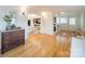 Elegant hallway with wood floors, antique dresser, and view into living room at 107 Westwood Dr, Belmont, NC 28012