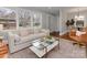 Living room with light beige couch, coffee table, and view into dining area at 1156 Brighton Pl, Charlotte, NC 28205