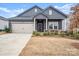 Two-story home with gray siding, beige garage door, and landscaping at 11818 Red Leaf Dr, Charlotte, NC 28215