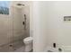 Modern bathroom with a glass shower, toilet and neutral tile at 138 Pounds Sw Ave, Concord, NC 28025