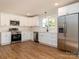 Modern kitchen with white cabinets, stainless steel appliances, and hardwood floors at 138 Pounds Sw Ave, Concord, NC 28025