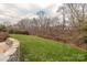 Spacious backyard with stone wall and mature trees at 6906 Red Maple Dr, Charlotte, NC 28277