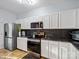 Modern kitchen with white cabinets, stainless steel appliances, and dark countertops at 7148 Abbotts Glen Dr, Charlotte, NC 28212