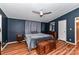 Serene bedroom with dark blue walls, ceiling fan, and wooden dresser at 8327 Walkup Rd, Waxhaw, NC 28173