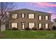 Two-story brick home with lights on at dusk at 5314 Auburn Hill Ln, Charlotte, NC 28269