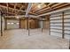 Unfinished basement garage area with shelving and a separate door at 116 Cherokee Se Dr, Concord, NC 28025