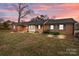 Brick ranch house with blue shutters, landscaped lawn, and a walkway at 116 Cherokee Se Dr, Concord, NC 28025