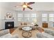 Living room with corner fireplace, hardwood floors and large windows at 14132 Green Birch Dr, Pineville, NC 28134