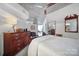 Bedroom with a wooden sleigh bed, dresser, and ceiling fan; view of bathroom at 210 N Church St # 1213, Charlotte, NC 28202