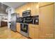 Modern kitchen with stainless steel appliances and light wood cabinets at 210 N Church St # 1213, Charlotte, NC 28202