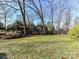 Large backyard with grassy area, wooden fence, and mature trees at 4511 Twin Oaks Pl, Charlotte, NC 28212