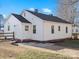 Rear view of a white ranch home with a small patio area at 8532 Old Plank Rd, Charlotte, NC 28216