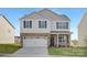 Two-story house with a neutral color brick and vinyl siding, a two-car garage and landscaping at 3453 Buck Ct, Gastonia, NC 28056