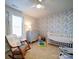 Bedroom with floral wallpaper, crib, and rocking chair at 8216 Waxhaw Hwy, Waxhaw, NC 28173