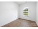 Simple bedroom with wood-look flooring and a window with natural light at 1019 Cathey Rd, Charlotte, NC 28214