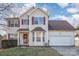 Two-story house with beige siding, maroon accents, and a two-car garage at 211 Fox Hollow Rd, Mooresville, NC 28117