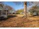 Yard with mature trees and leaf covered ground at 209 E Dixon St, Lincolnton, NC 28092