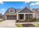 Gray-sided house with stone accents, brown garage doors, and manicured landscaping at 10118 Passau Path Dr, Huntersville, NC 28078