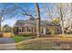 Brick ranch house with a driveway and a large tree in the front yard at 5706 Wadebridge Cv, Charlotte, NC 28210