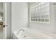 Bathroom with a bathtub and a block window for natural light at 1003 Blue Range Rd, Indian Trail, NC 28079