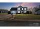 Two-story house with gray siding, stone accents, and a neatly landscaped lawn at dusk at 5732 Cardington Ct, Charlotte, NC 28216