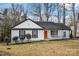 Charming one-story home with white siding, a red door, and landscaping at 1919 Crooked Creek Dr, Charlotte, NC 28214