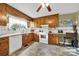 Galley kitchen with wood cabinets, white appliances, and tile floor at 2385 Deertrack Cir, Lancaster, SC 29720