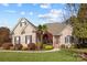 Brick home with landscaping, red door, and a palm tree in the front yard at 5422 Glen Forest Dr, Charlotte, NC 28226