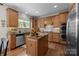 Kitchen boasts granite island, stainless steel appliances, and wood cabinetry at 10418 Annie Oakley Ln, Charlotte, NC 28227