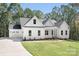 White farmhouse exterior with a charming front porch and attached two-car garage at 131 High Lake Dr, Statesville, NC 28677