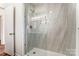 Walk-in shower with glass enclosure and marble tile at 129 N Magnolia St, Mooresville, NC 28115