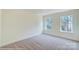 Bright bedroom with neutral carpeting and two windows at 2024 Embassy Ct # 49, Charlotte, NC 28213