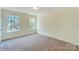 Bright bedroom with neutral carpeting and two windows at 2024 Embassy Ct # 49, Charlotte, NC 28213
