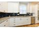 White kitchen cabinets, granite countertops, and black tile backsplash at 7542 Waverly Walk Ave # 7542, Charlotte, NC 28277