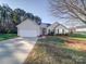 Tan house with a two-car garage and landscaping at 537 Scarlet Leaf Ln, Oakboro, NC 28129