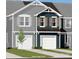 Two-story townhome with gray and blue siding, two-car garage, and landscaping at 7224 Hodges Meadow Ln, Charlotte, NC 28213