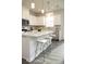 White kitchen with island and breakfast bar, stainless steel appliances, and gray flooring at 7224 Hodges Meadow Ln, Charlotte, NC 28213