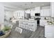 Open kitchen with white cabinets, island, stainless steel appliances, and gray flooring at 7224 Hodges Meadow Ln, Charlotte, NC 28213