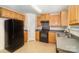 Bright kitchen features light wood cabinets, black appliances, and a double sink at 10609 Turkey Point Dr, Charlotte, NC 28214