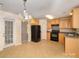 Kitchen with light wood cabinets, black appliances, and tiled floor at 10609 Turkey Point Dr, Charlotte, NC 28214