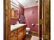 Charming bathroom with wood vanity and patterned wallpaper at 38899 Dalton Ln, Albemarle, NC 28001