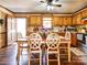 Bright kitchen with wooden cabinets, a dining table, and access to a laundry area at 38899 Dalton Ln, Albemarle, NC 28001