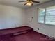 Living room with maroon carpet and ceiling fan at 145 Mccarver Rd, Gastonia, NC 28056