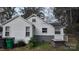 Side view of a white house with gray brick foundation and landscaping at 5917 Peach St, Charlotte, NC 28269