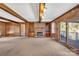 Living room with hardwood floors, a brick fireplace, built-in shelves, and access to a deck at 8031 Nathanael Greene Ln, Charlotte, NC 28227