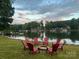 Serene lakeside firepit area with red chairs and beautiful views at 7930 Blackwood Rd, Denver, NC 28037