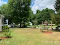 Spacious side yard with a wooden cross and bench at 507 North Dr, Cherryville, NC 28021